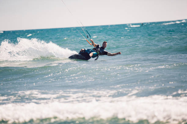 istock Kitesurfing. Man rides on kite on waves 1167235636