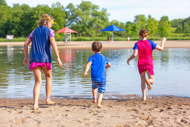 istock Two Girls & Boy Running Into Water At Beach 1167236575