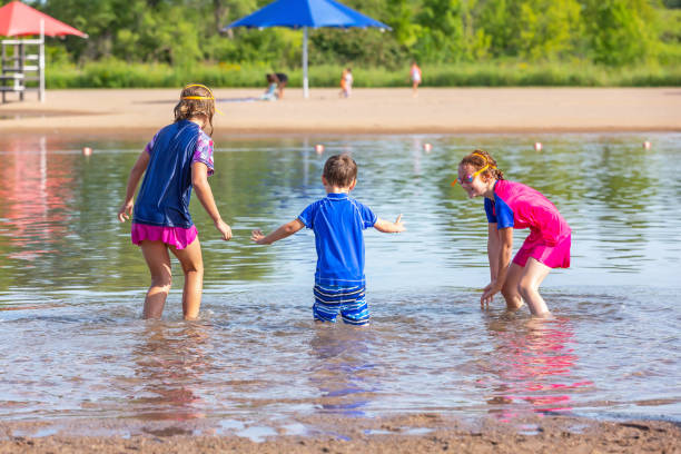 istock Two Girls & Boy Running Into Water At Beach 1167236589