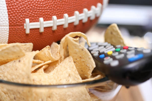 Watching the football game with snacks.