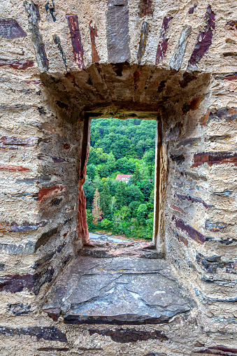 Vianden, Luxembourg - August 8, 2019: View of the mountain and forest in Vianden, Luxembourg, from an arch inside the Vianden Castle.