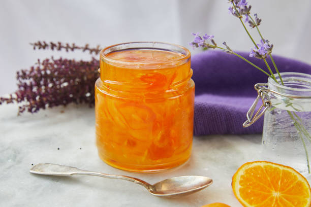 słodki pomarańczowy dżem cytruce i fiołek na marmurze - lavender orange fruit table zdjęcia i obrazy z banku zdjęć