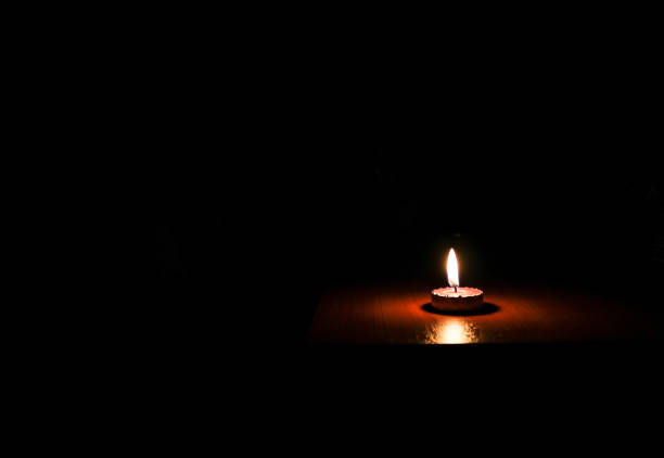 istock One light candle burning brightly in the black background 1167248833