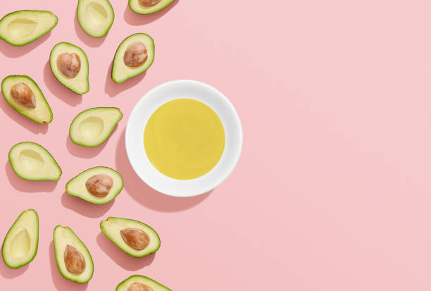 avokadoolja och halveras avokado på rosa bakgrund - avocado oil bildbanksfoton och bilder