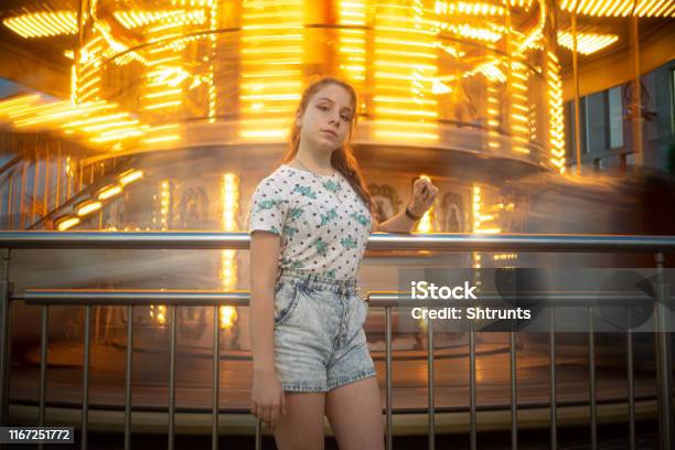 Teenage Girl Stands Close To A Spinning Carousel Stock Photo - Download Image Now - 12-13 Years, 14-15 Years, Blue