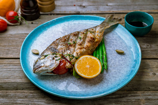 istock Dorado on grill at blue plate on old wooden table 1167253063