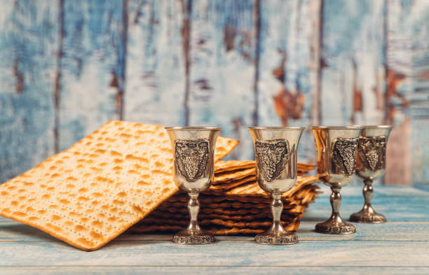 fundo do passover quatro vidros vinho e pão judaico do feriado do matzoh sobre a placa de madeira. - kosher wine - fotografias e filmes do acervo