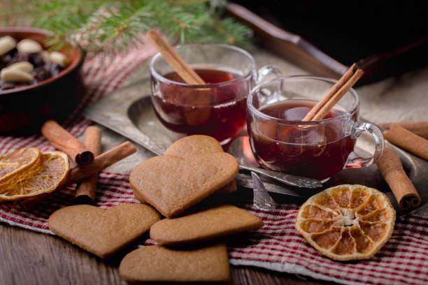 Mulled wine and swedish gingerbread cookies Mulled wine with cinnamon sticks, known as  glögg in Sweden. The glasses are on an old metal tray surronded by heart shaped traditional swedish gingerbread cookies, dried orange slices and a bowl of almonds and raisins. mulled wine photos stock pictures, royalty-free photos & images