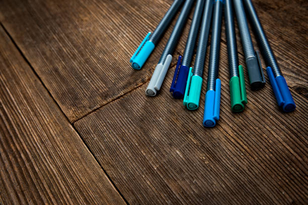 This is a photograph of markers on a retro old wood background. These symbolize a variety of high key art supplies