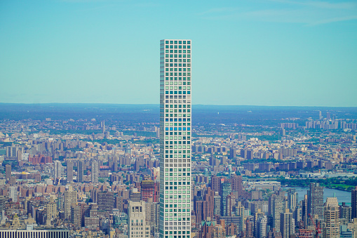 A photo of the Tallest Residential Building on the Western Hemisphere, 432 Park Avenue, in Manhattan, New York, part of the skyline, standing tall with the rest of the concrete jungle that is New York City in the background.