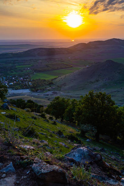 istock Colorful sunset viewed from Tutuiatu peak in ancient eroded Macin mountains with Greci village far down in the backround in Romania during spring-summer 1167265782
