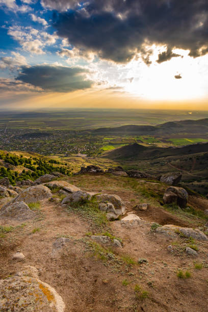 istock Colorful sunset viewed from Tutuiatu peak in ancient eroded Macin mountains with Greci village far down in the backround in Romania during spring-summer 1167265896