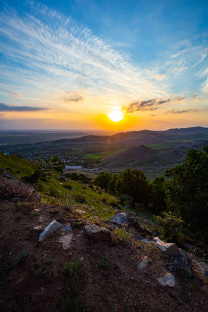 istock Colorful sunset viewed from Tutuiatu peak in ancient eroded Macin mountains with Greci village far down in the backround in Romania during spring-summer 1167265916