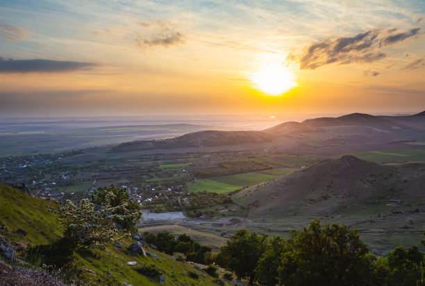 istock Colorful sunset viewed from Tutuiatu peak in ancient eroded Macin mountains with Greci village far down in the backround in Romania during spring-summer 1167265968