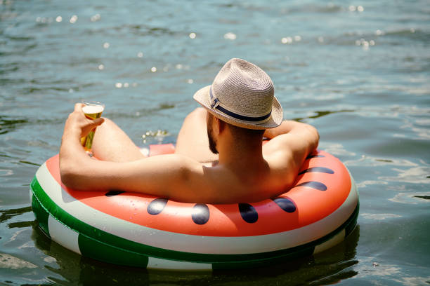 отдых на резиновом кольце в воде. - inner tube swimming lake water стоковые фото и изображения