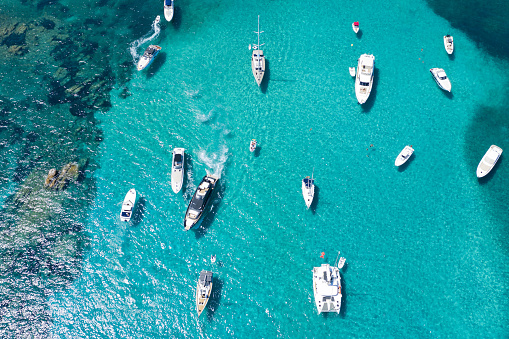 View from above, stunning aerial view of a beautiful bay with turquoise water full of boats and luxury yachts. Liscia Ruja, Emerald Coast (Sardinia) Sardinia, Italy.