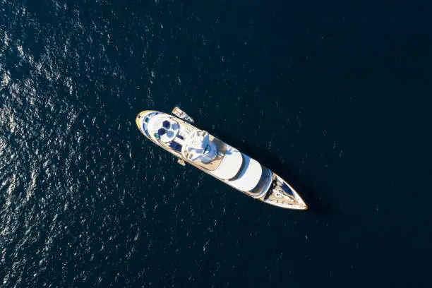 View from above, stunning aerial view of a luxury yacht sailing on a blue sea. Emerald Coast (Costa Smeralda) Sardinia, Italy.