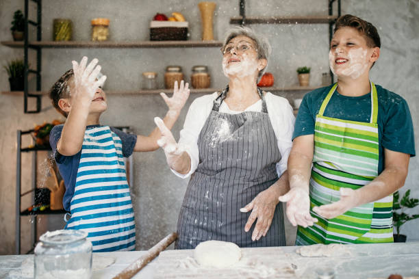 istock Kids playing with their grandmother in kitchen, making a cake 1167269137