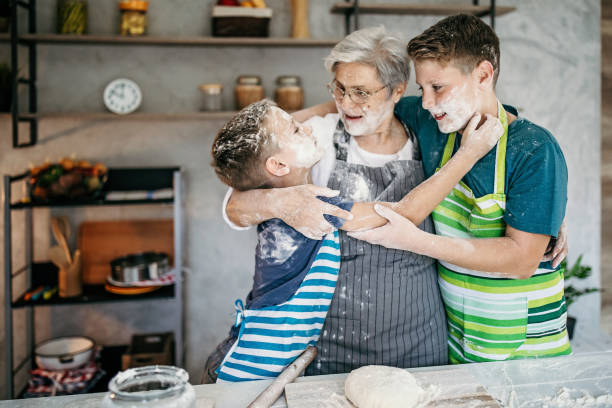 istock Kids playing with their grandmother in kitchen, making a cake 1167269152