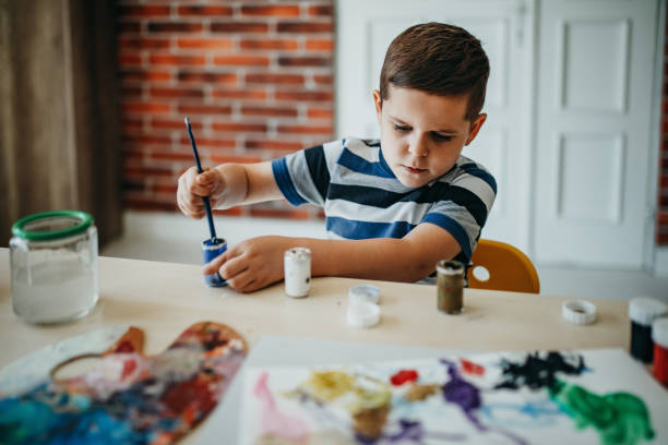 Boy draws in water colors
