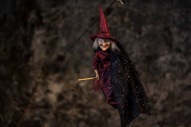istock Witch with broomstick and hat hanging on the ceiling. Halloween decoration 1167271345