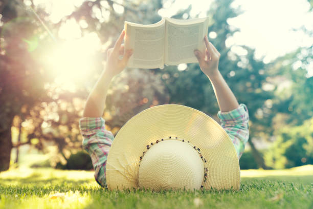 istock Young Girl Lying on Grass and Reading Book. 1167279684