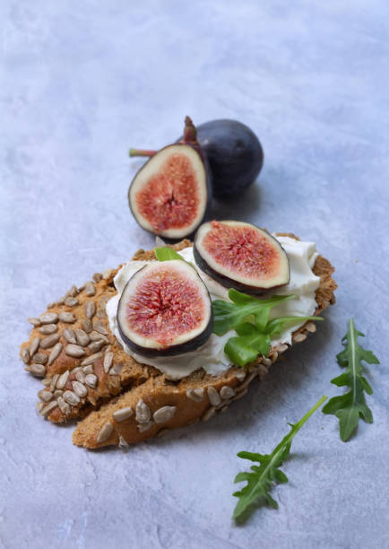 istock Open sandwich with cream cheese and figs on grey background. 1167280247