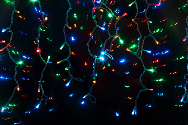 istock Multi-colored garland on a black background. Concept Christmas or New Year. Selective focus and shallow depth of field. 1167286706