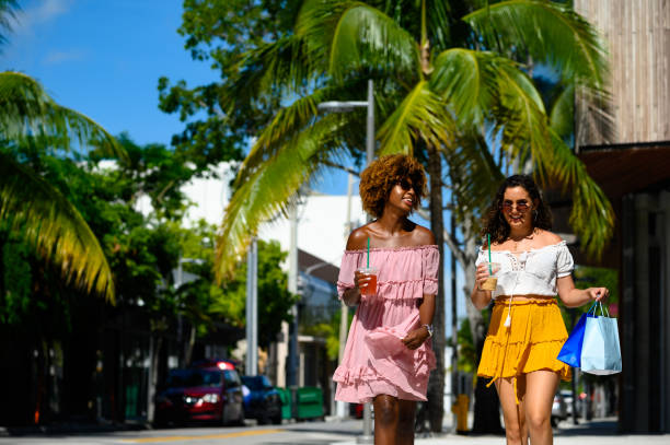 молодые женщины наслаждаются городской жизнью в солнечный день - women dress black young women стоковые фото и изображения