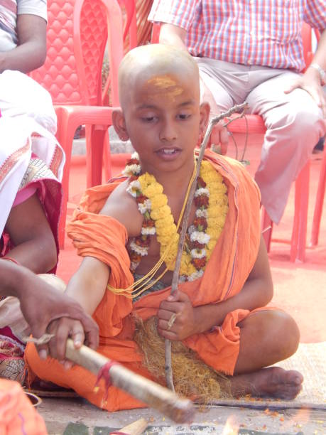 hindu brahmins upanayana ou le fil sacré (yagyopavita ou janeu) cérémonie. un garçon pendant son rituel upanayana. le fil yajnopavita mince et jaune va de l'épaule gauche à la taille. notez la ceinture d'herbe munja autour de la taille. la brindille  - peepal photos et images de collection