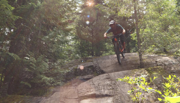 istock Male mountain biker descends steep slab through forest 1167295283