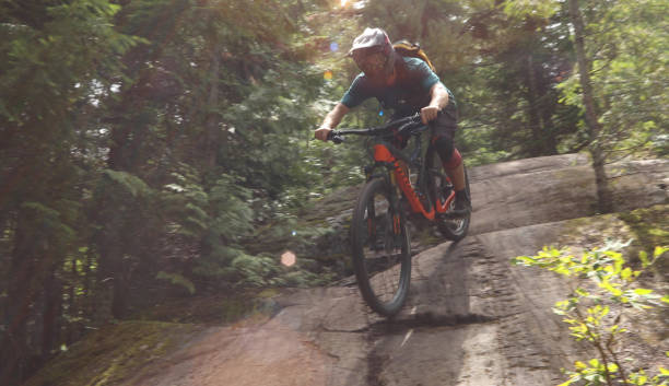 istock Male mountain biker descends steep slab through forest 1167295328