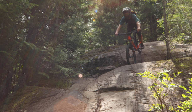 istock Male mountain biker descends steep slab through forest 1167295336