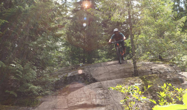 istock Male mountain biker descends steep slab through forest 1167295378