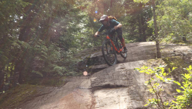 istock Male mountain biker descends steep slab through forest 1167295381