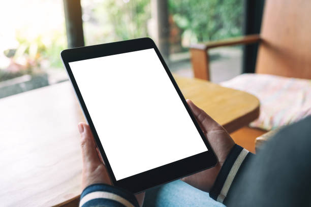 istock a woman sitting and holding black tablet pc with blank white desktop screen 1167298705