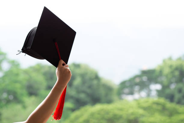 istock Graduation day,raising hands with graduation cap on green background.Commencement day, Congratulation 1167303593