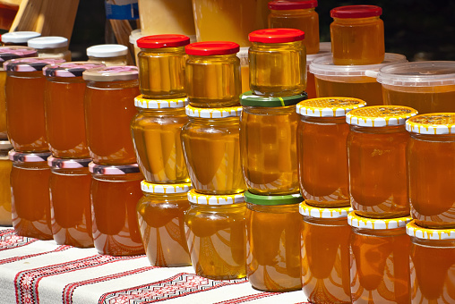 Lots of assorted honey on the table. Jars of sweets are sold at the fair.
