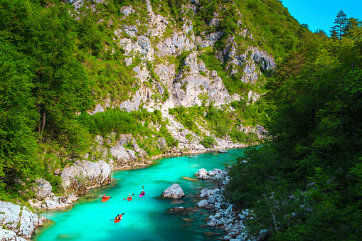 Popular rafting and kayaking locations. Active kayakers paddling on the emerald color Soca river, near Kobarid, Triglav National Park, Slovenia, Europe