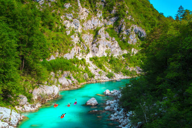 Kayakers on the spectacular turquoise Soca river, Kobarid, Slovenia Popular rafting and kayaking locations. Active kayakers paddling on the emerald color Soca river, near Kobarid, Triglav National Park, Slovenia, Europe soca valley stock pictures, royalty-free photos & images