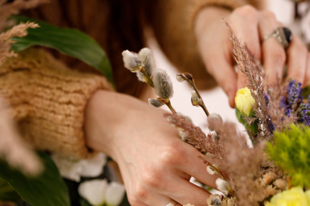 istock Female hand composing a composition of heather flowers and willow branches. The concept of tenderness. 1167318655