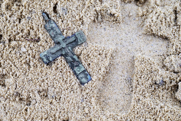 istock footprint in the sand from a large cross lying next to a small 1167320550