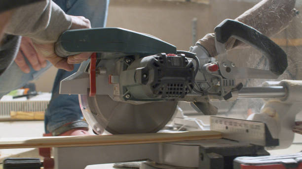 istock Carpenter cutting a plank with circular saw 1167327520