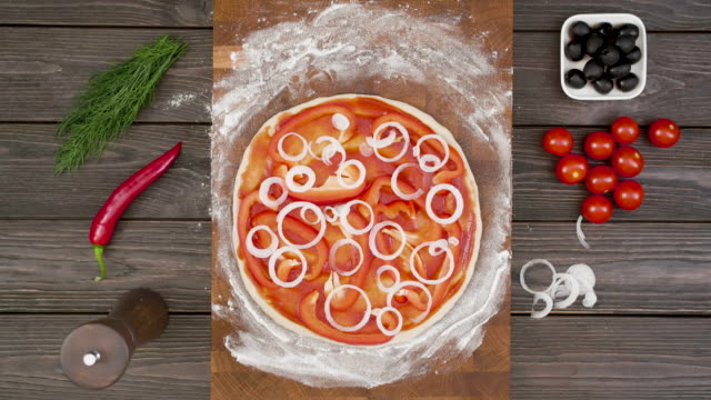 Top view of vegetarian pizza on wooden plate on the table, stop motion animation