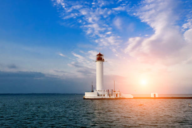 istock lighthouse in the sea at sunset 1167328956