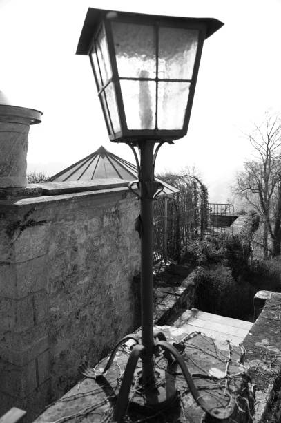 istock Retro-style cast iron lamp on stone wall in black and white 1167330151