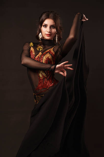 istock Beautiful belly dancer perfuming exotic dance in red flutter dress 1167330466