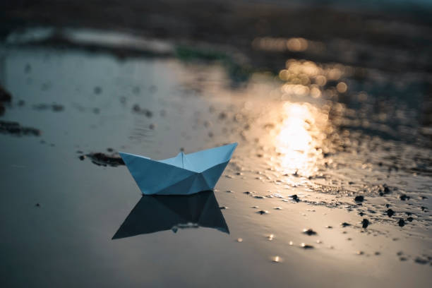 istock Paper boat on beach on sunset time 1167331074