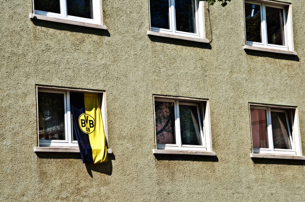 A Borussia Dortmund FC fan display the club's flag through a residential apartment window in Dortmund - Germany. A Borussia Dortmund FC fan display the club's flag through a residential apartment window in Dortmund - Germany. club soccer photos stock pictures, royalty-free photos & images