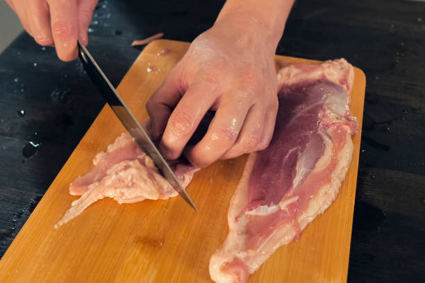 istock Cutting poultry meat. Broiler breast, chicken meat on cutting bo 1167331832